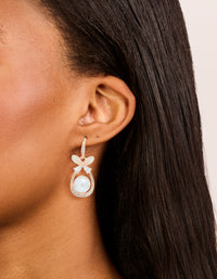 Elegant butterfly and pearl oval hook earrings crafted from rose gold plated material with cubic zirconia, styled on ear view - link has visual effect only