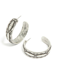 Beautifully crafted antique silver textured hoop earrings with intricate engraved detailing in front view - link has visual effect only