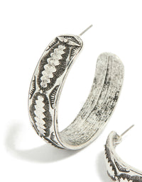 Showcasing antique silver textured hoop earrings featuring ornate engraved patterns in close up view - link has visual effect only