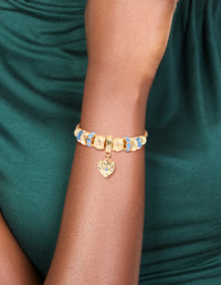 Showcasing a gold blue diamante and molten heart charm toggle bracelet with beaded and balls details on wrist view - link has visual effect only