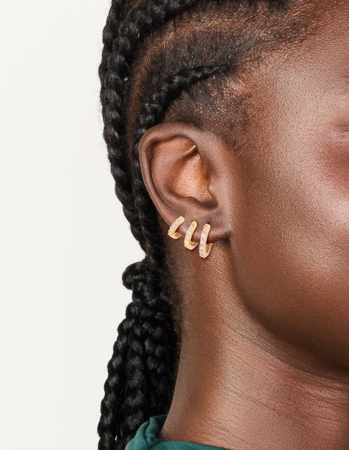 Featuring gold light pink cubic zirconia simple huggie earrings in a 3-pack on ear view