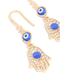 Detailed view of gold cubic zirconia evil eye and hamsa hand drop earrings featuring charm, royal blue, white, and black close up view - link has visual effect only