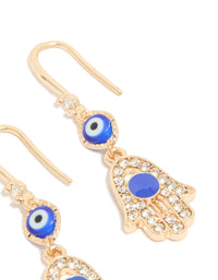 Highlighting gold cubic zirconia evil eye and hamsa hand drop earrings with charm, royal blue, white, and black details from side angle post view - link has visual effect only