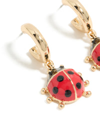 Explore gold ladybug huggie earrings in red and black close up view - link has visual effect only