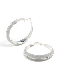 Showcasing silver glitter hoop earrings front view - link has visual effect only