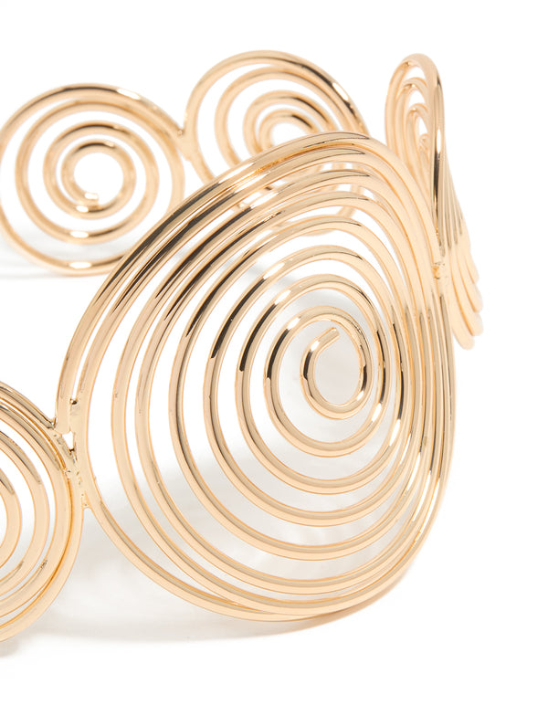 Featuring a gold multi swirl arm cuff bangle with statement design close up view