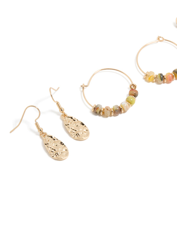 Showcasing gold beaded hoop and drop earrings 3-pack with charms featuring hoop closure in orange, tan, and coral tones close up view