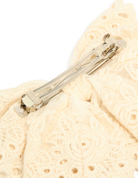 Close-up of cream broderie triple layered fabric bow hair clip showing metal clasp detail view - link has visual effect only