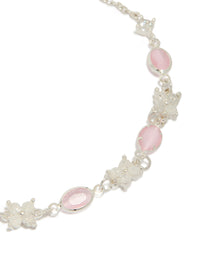 Featuring floral and charms, this silver plated oval cubic zirconia toggle bracelet highlights pink and clear stone detailing close up view - link has visual effect only