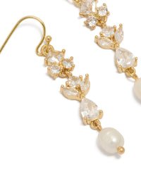 Showcasing gold plated cubic zirconia and freshwater pearl vine hook drop earrings featuring charm accents close up view - link has visual effect only