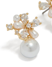 Crafted from gold plated material, these cubic zirconia flower pearl drop stud earrings feature white and ivory tones close up view - link has visual effect only