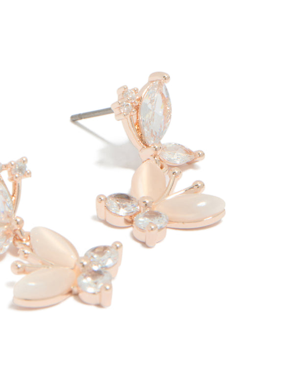 Beautiful drop earrings with double butterfly charm featuring cubic zirconia in rose gold plated finish post detail view