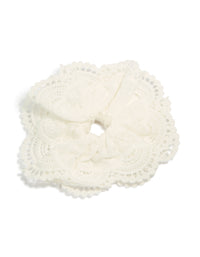 Showcasing a white fabric broderie edge statement scrunchie with floral embroidered detailing in solid front view - link has visual effect only