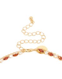 Highlighting the gold plated red cubic zirconia tennis and teardrop charm layer necklace with statement styling clasp detail view - link has visual effect only