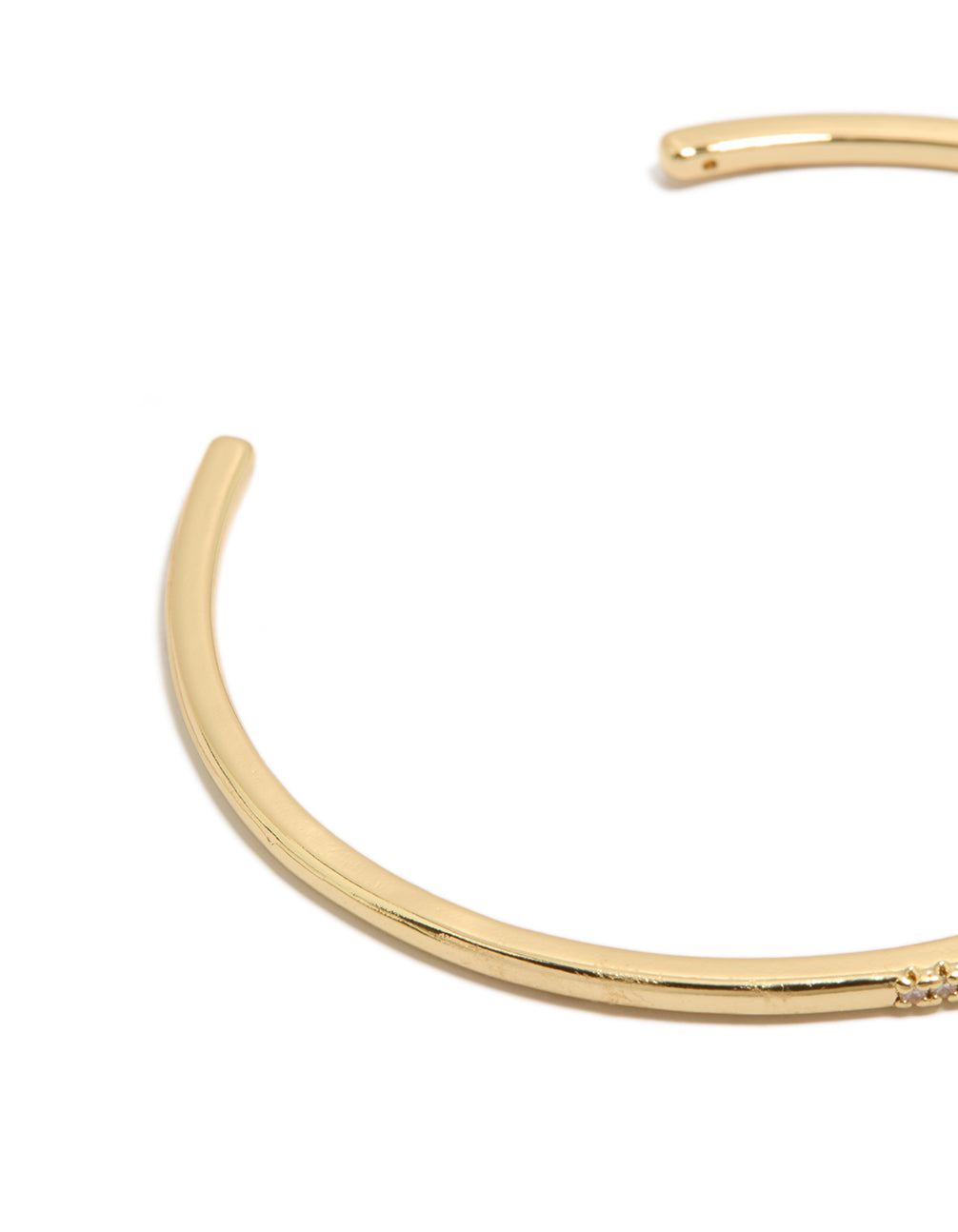 Showcasing a gold plated thin wrist cuff bangle with cubic zirconia closure detail view