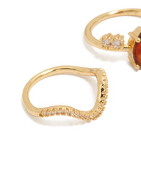 Featuring gold plated red cubic zirconia teardrop and wavy rings 3-pack with crystal embellishments in statement style close up view - link has visual effect only