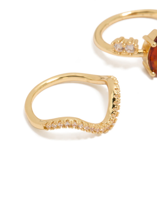 Featuring gold plated red cubic zirconia teardrop and wavy rings 3-pack with crystal embellishments in statement style close up view