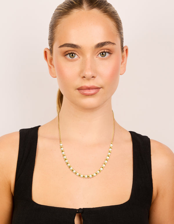 Designed with alternating balls and pearl accents crafted from waterproof stainless steel in gold plated finish on model view