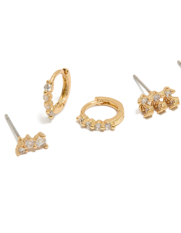Featuring dainty gold plated cubic zirconia trio studs and huggie earrings in a 3-pack close up view