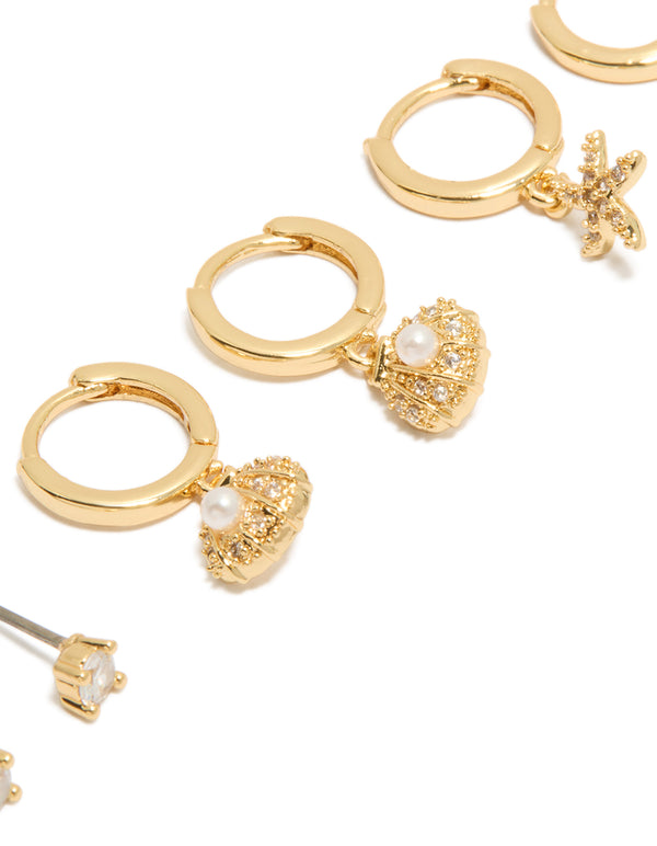Crafted from gold plated materials, cubic zirconia studs and mini starfish huggie earrings 3-pack with shell, ocean pearl crystal close up view