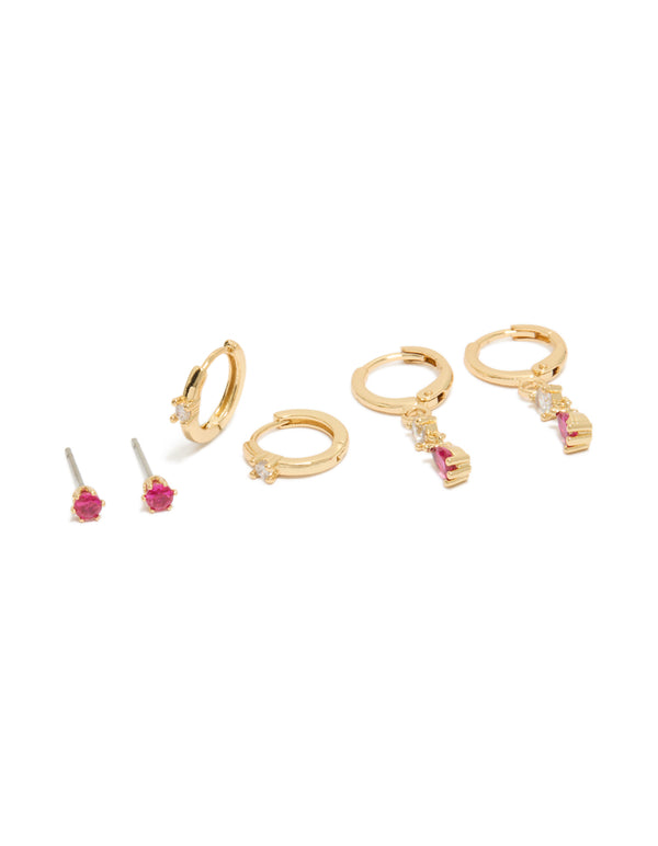 Dainty gold plated studs and huggie earrings 3-pack featuring dark pink cubic zirconia with crystal accents front view