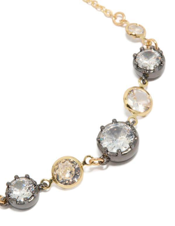 Showcasing a mixed metal plated toggle bracelet with cubic zirconia and crystal accents in gold, silver, and clear close up view