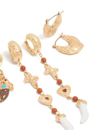 Designed with worn gold statement earrings 3-pack featuring beads, charm, cross, heart, and stud, huggie closure post detail view - link has visual effect only