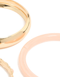 Featuring chunky gold textured and resin bangles in a 3-pack with peachpuff accents close up view - link has visual effect only
