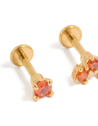 Presenting titanium stud earrings crafted from gold plated metal with flat back closure and red cubic zirconia close up view - link has visual effect only