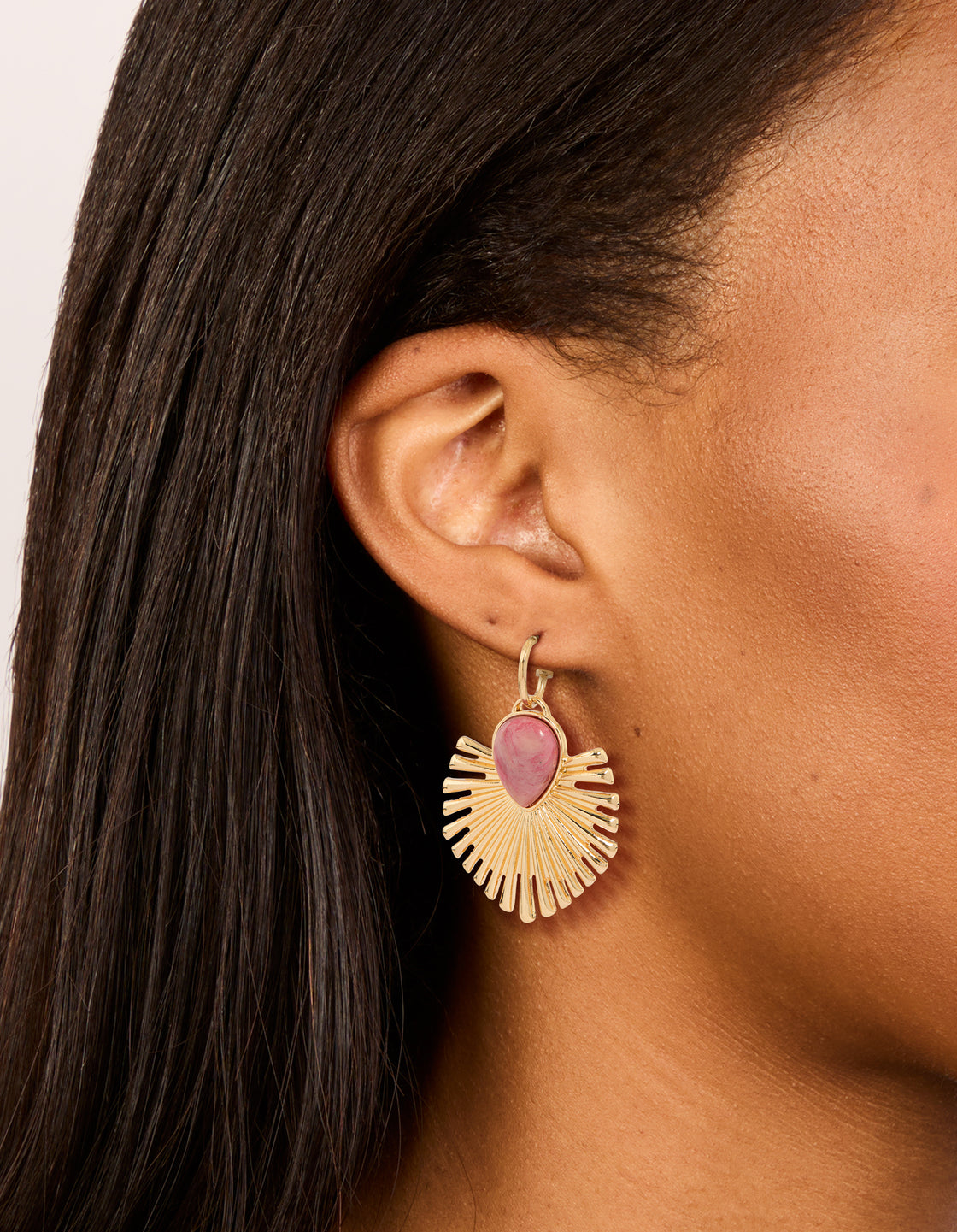 These gold pink stone fanned drop earrings with statement style on ear view