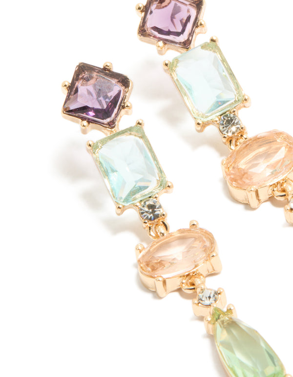 Highlighting gold irregular shaped purple and blue diamantes drop earrings in statement style close up view