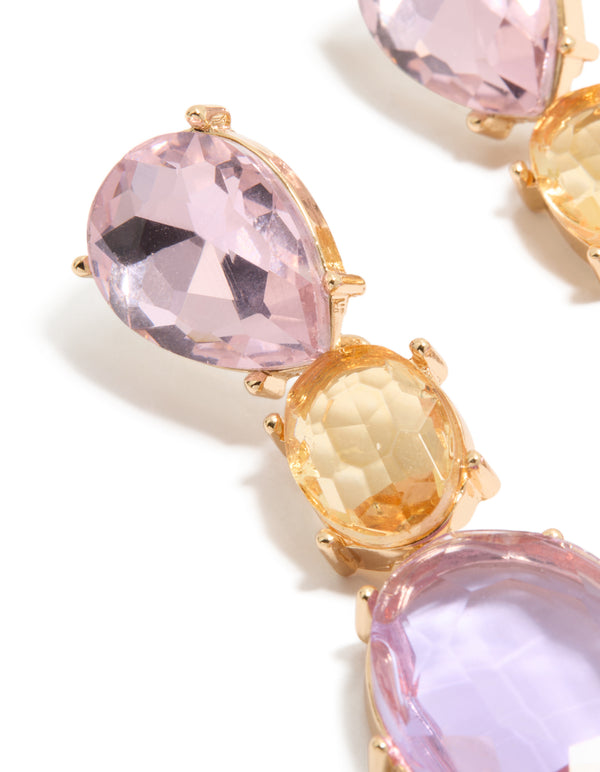 Showcasing statement drop earrings featuring purple and orange oval cut diamantes in gold close up view