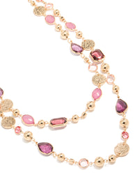 Beautifully crafted gold disc and pink beaded layered long necklace featuring charms in coral and purple accents in a chunky style close up view - link has visual effect only