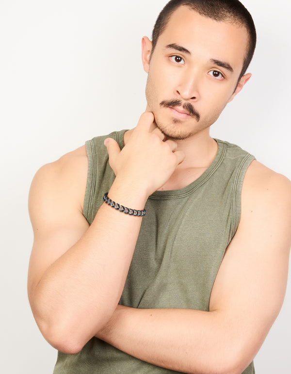 Crafted from waterproof stainless steel and black PU leather, this mens braided chain bracelet in silver on model view