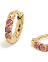 Detailed view of waterproof gold plated stainless steel pink cubic zirconia huggie earrings close up view - link has visual effect only