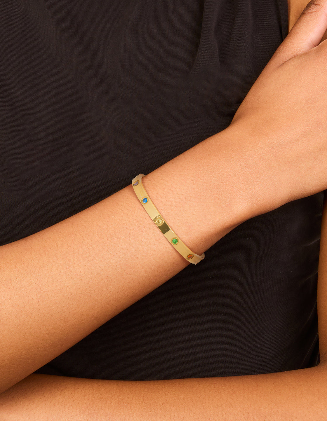 Featuring a waterproof gold plated stainless steel bangle with floral inlay cubic zirconia on wrist view