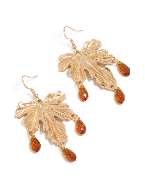 Featuring statement drop earrings with gold floral leaf design, orange beaded accents in front view