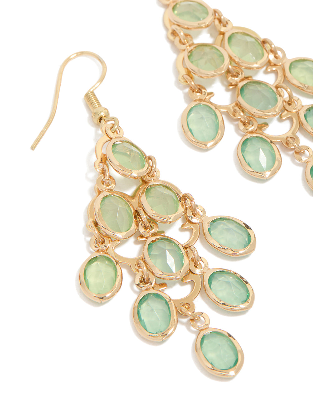 Highlighting statement style gold green diamantes cascading drop earrings featuring pale green stones close up view
