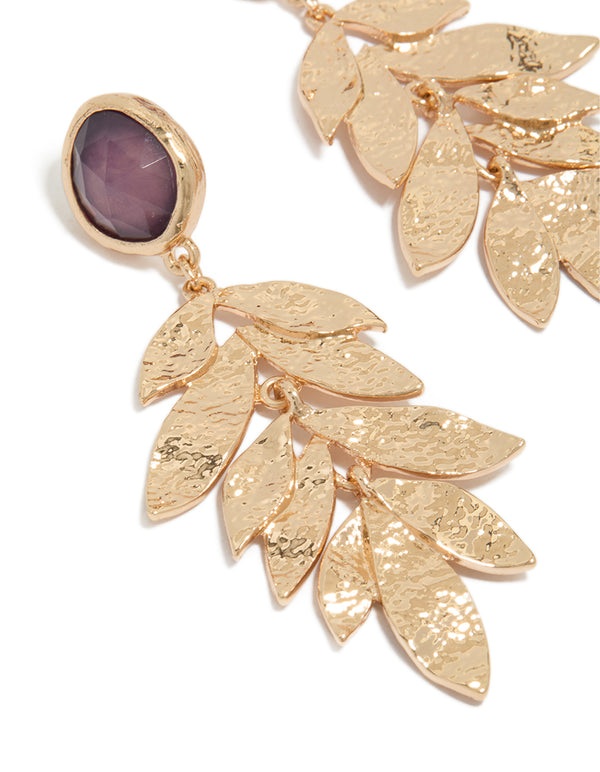 Designed with statement drop earrings featuring purple beads, textured layered petals in gold close up view