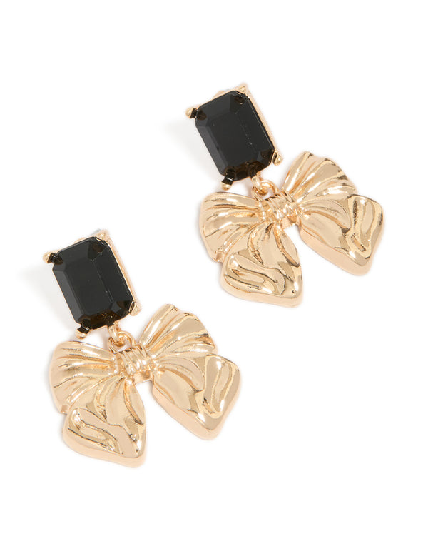 Statement drop earrings featuring bow design with black diamante stones in gold finish front view