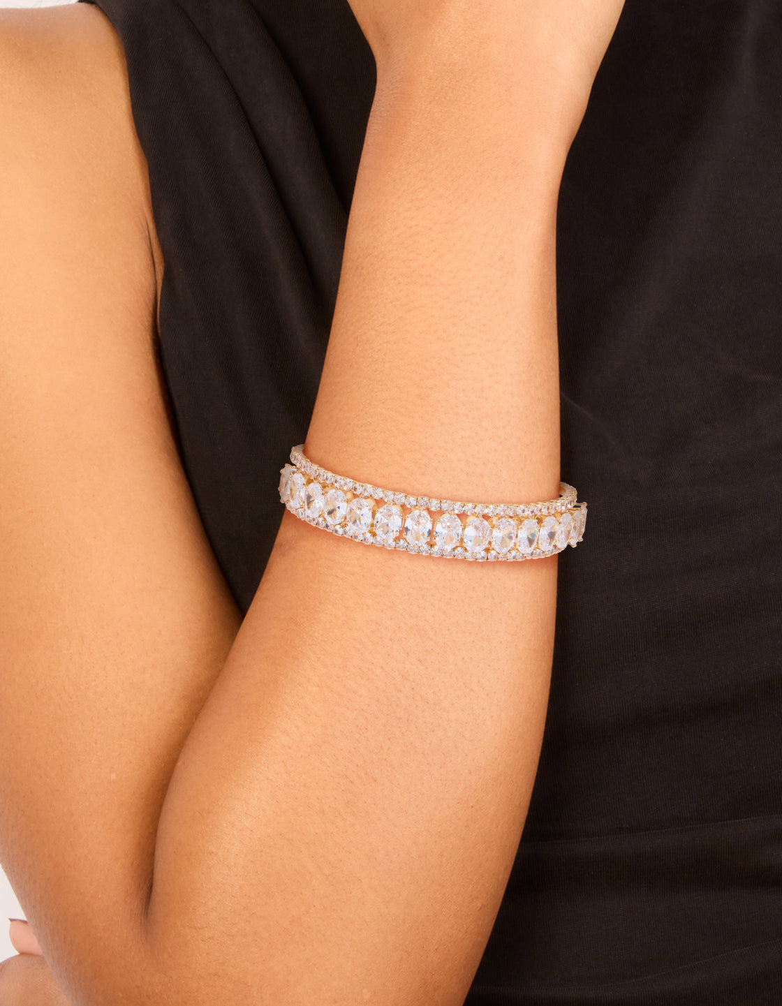 Displaying a gold statement wrist cuff crafted from oval cubic zirconia on wrist view